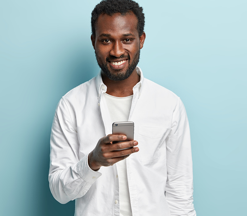 young black man looking at his mobile device and smiling