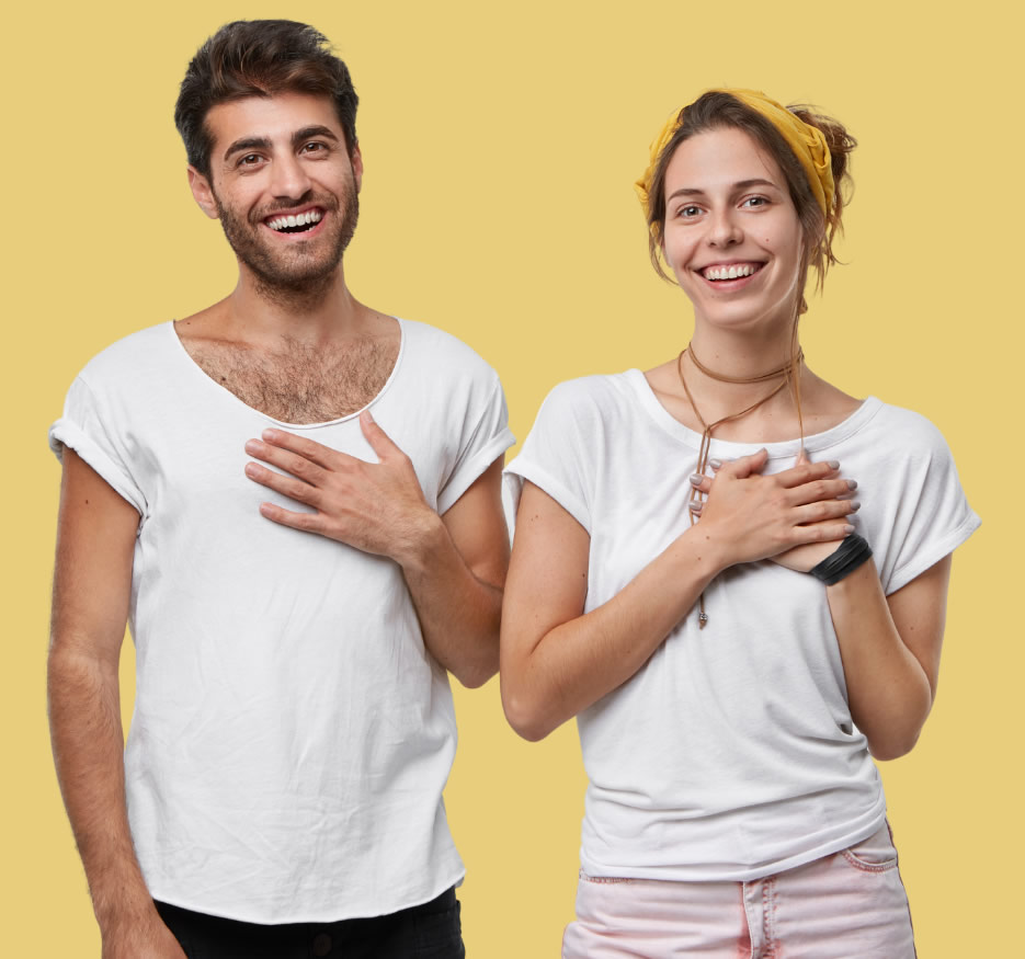 young couple in work clothes with hands over heart